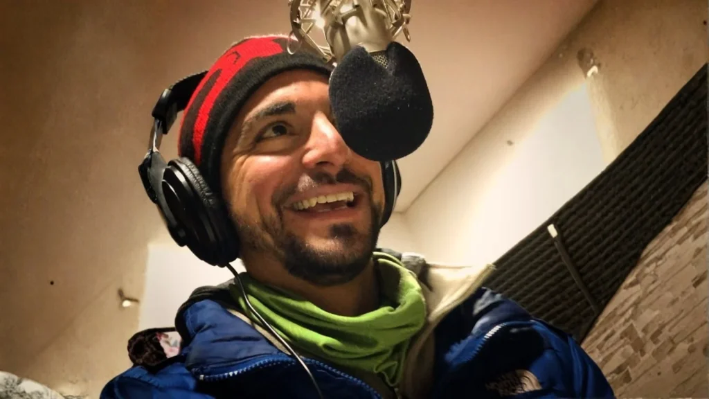 Mauricio Irigoyen sonríe con auriculares frente al micrófono en el estudio de FM Sapukay 89.1